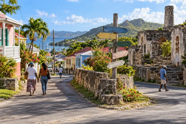 An Antiguan village junction with historic stonework, homes and residents