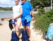 Two guests on the beach with fins, masks and sea scooters