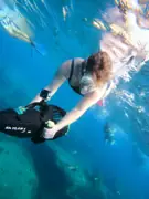 Snorkeler holding a sea scooter in clear blue water