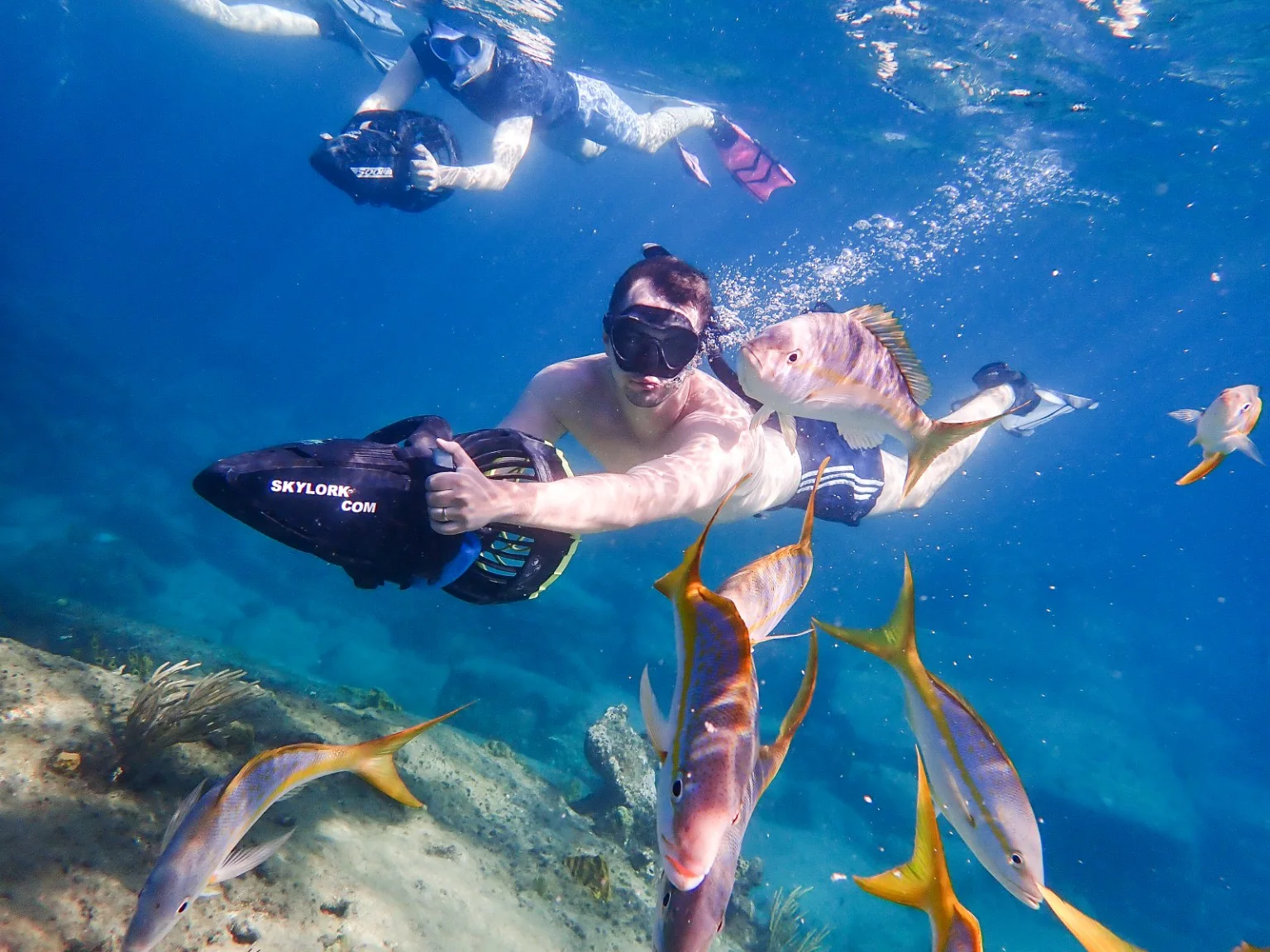 Guided sea scooter snorkelers exploring clear blue water in Antigua