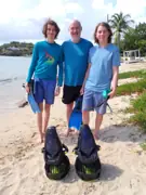 Three guests with fins and sea scooters on the beach