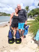 Two smiling guests with snorkeling equipment beside sea scooters