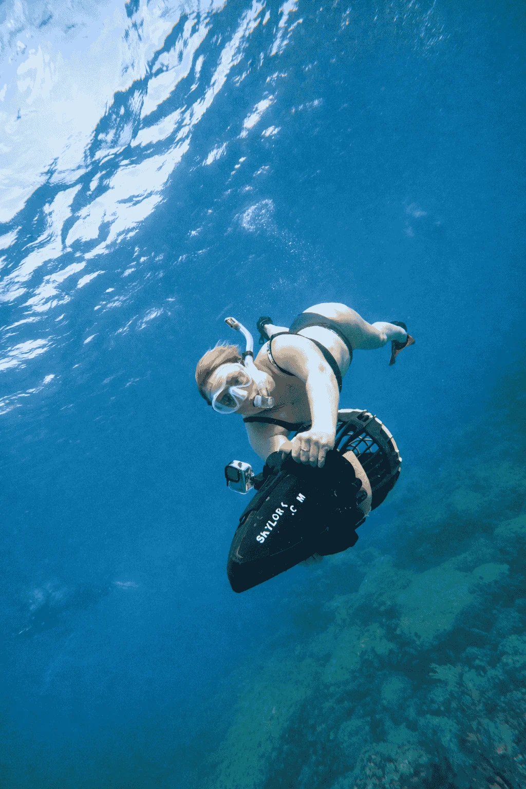 Snorkeler holding a sea scooter with Skylork branding