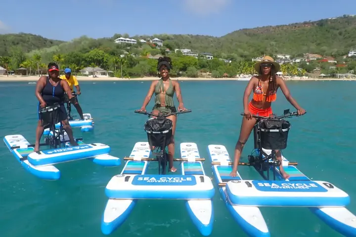 Three Sea Cycle riders on blue water bikes in turquoise water