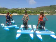 Three Sea Cycle riders on blue water bikes in turquoise water