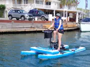 Guest riding a blue Sea Cycle water bike beside a dock