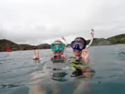 Two guests wearing masks and snorkels at the surface