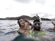 Two snorkelers floating at the surface near the coast