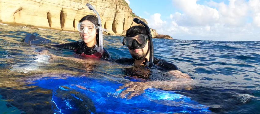 Vacation tourists surrounded by beautiful water and landscapes during underwater powered jetski scooter snorkeling tour in Antigua